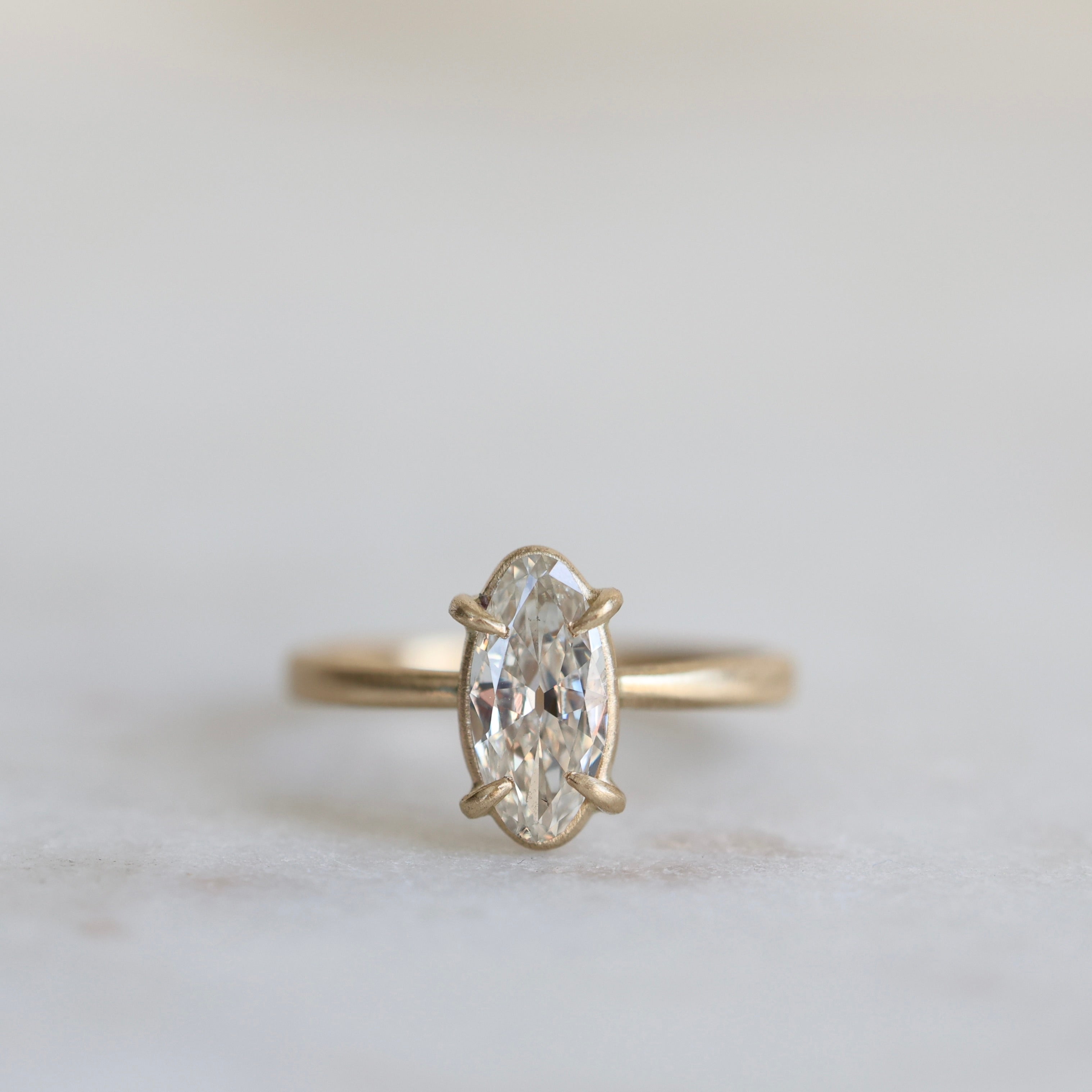 elongated oval diamond set in yellow gold ring with prongs