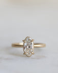 elongated oval diamond set in yellow gold ring with prongs