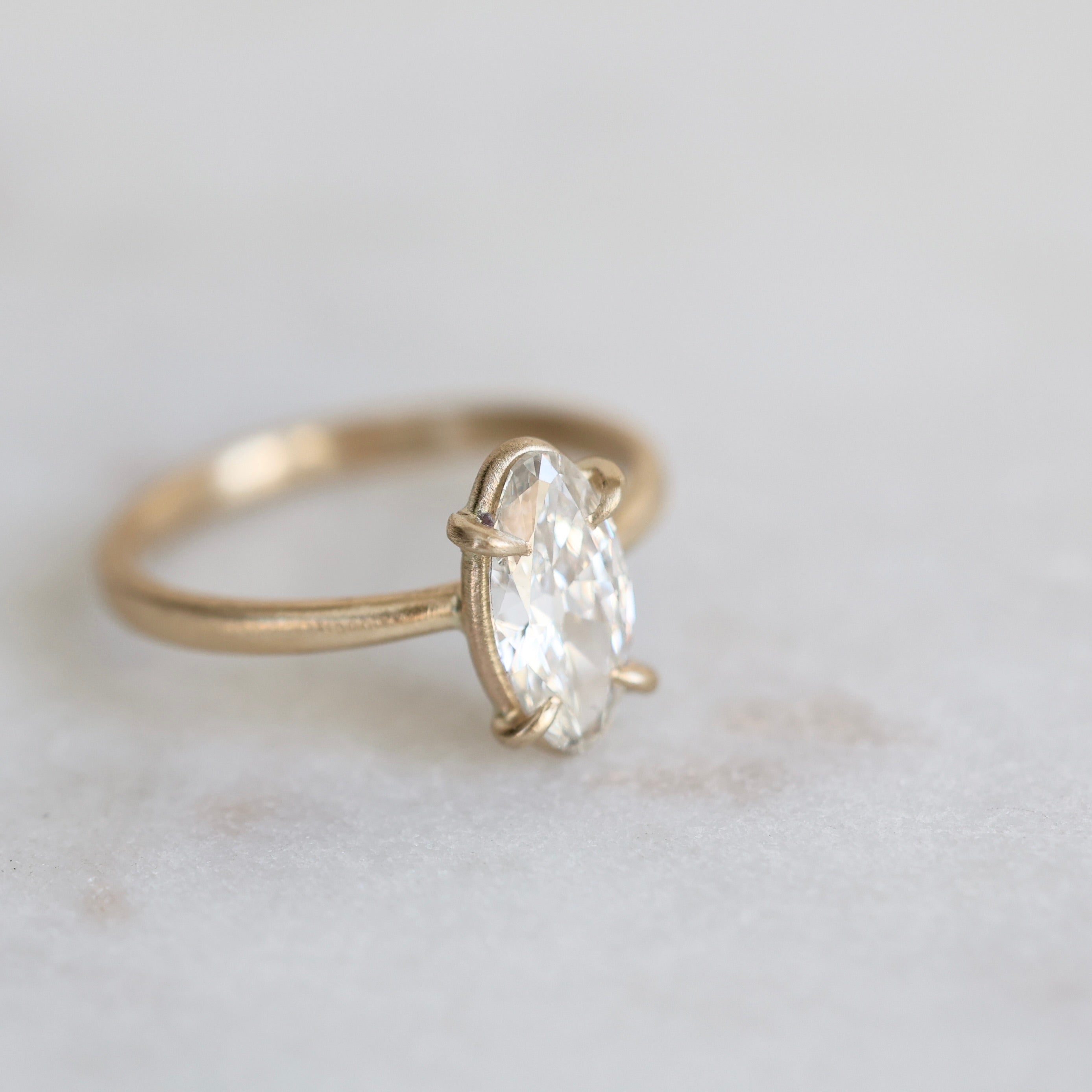 elongated oval diamond set in yellow gold ring with prongs
