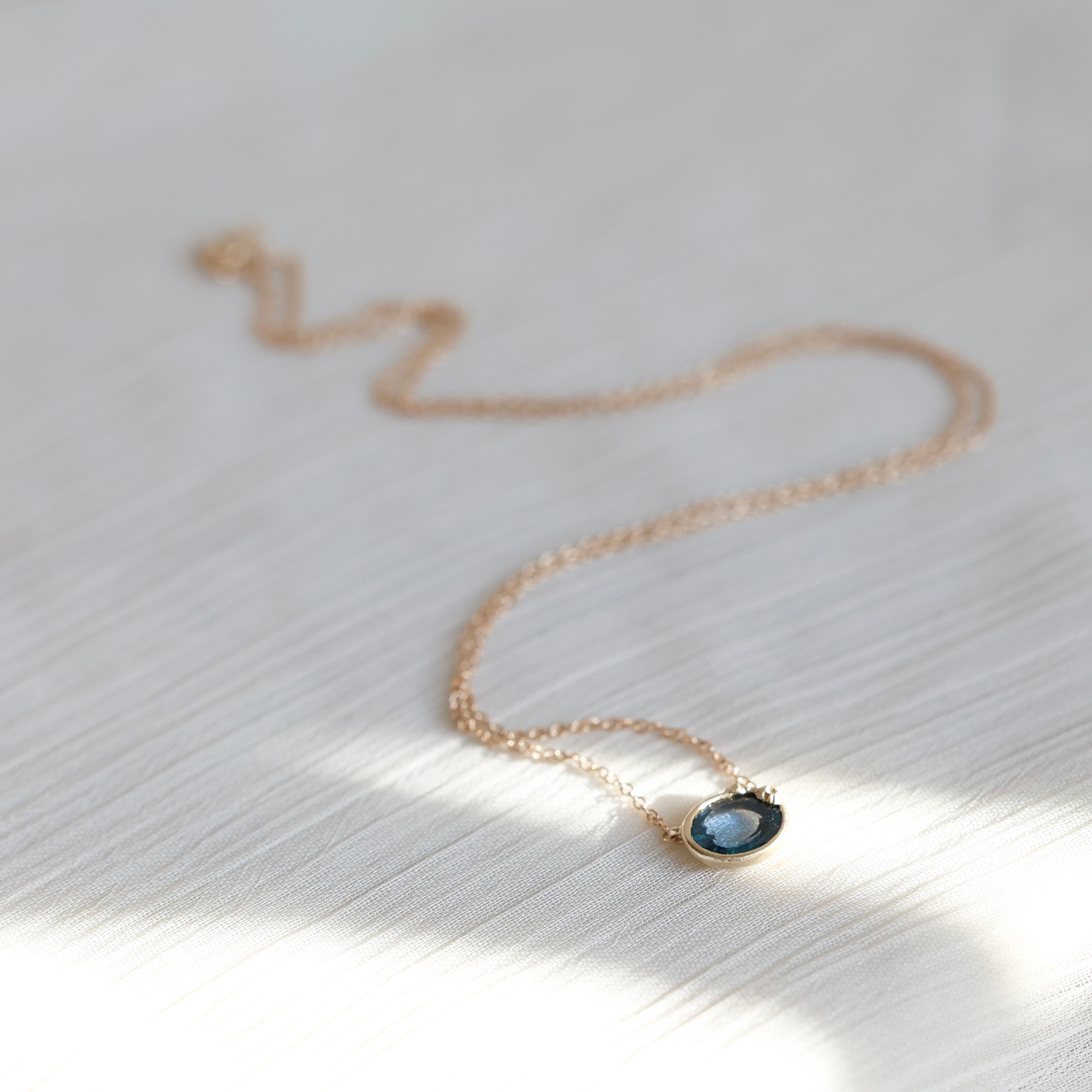 Necklace with a pendant on a textured white surface