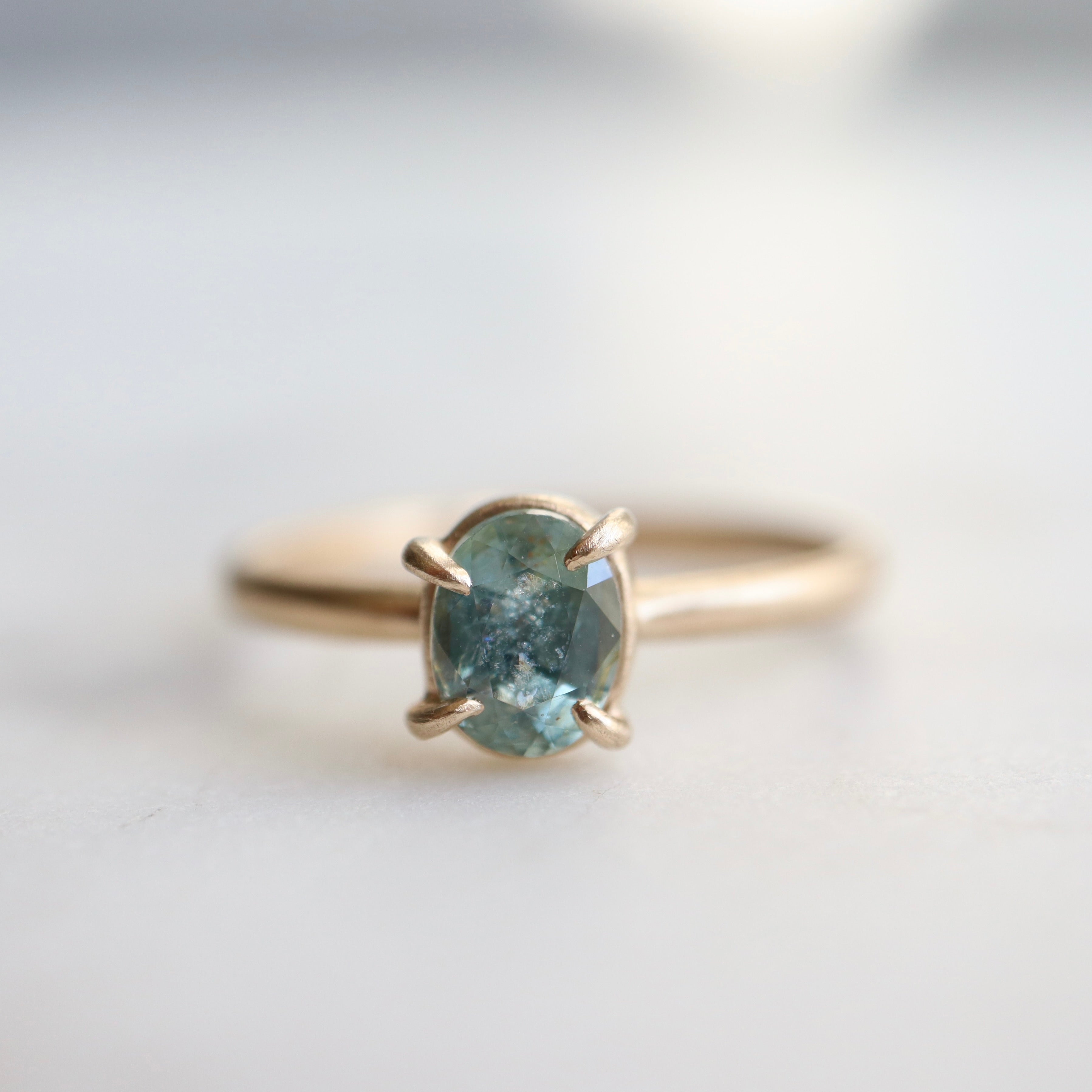 0.83ct Montana sapphire Vanity ring. The pale teal stone is set in 14k yellow gold with four prongs.