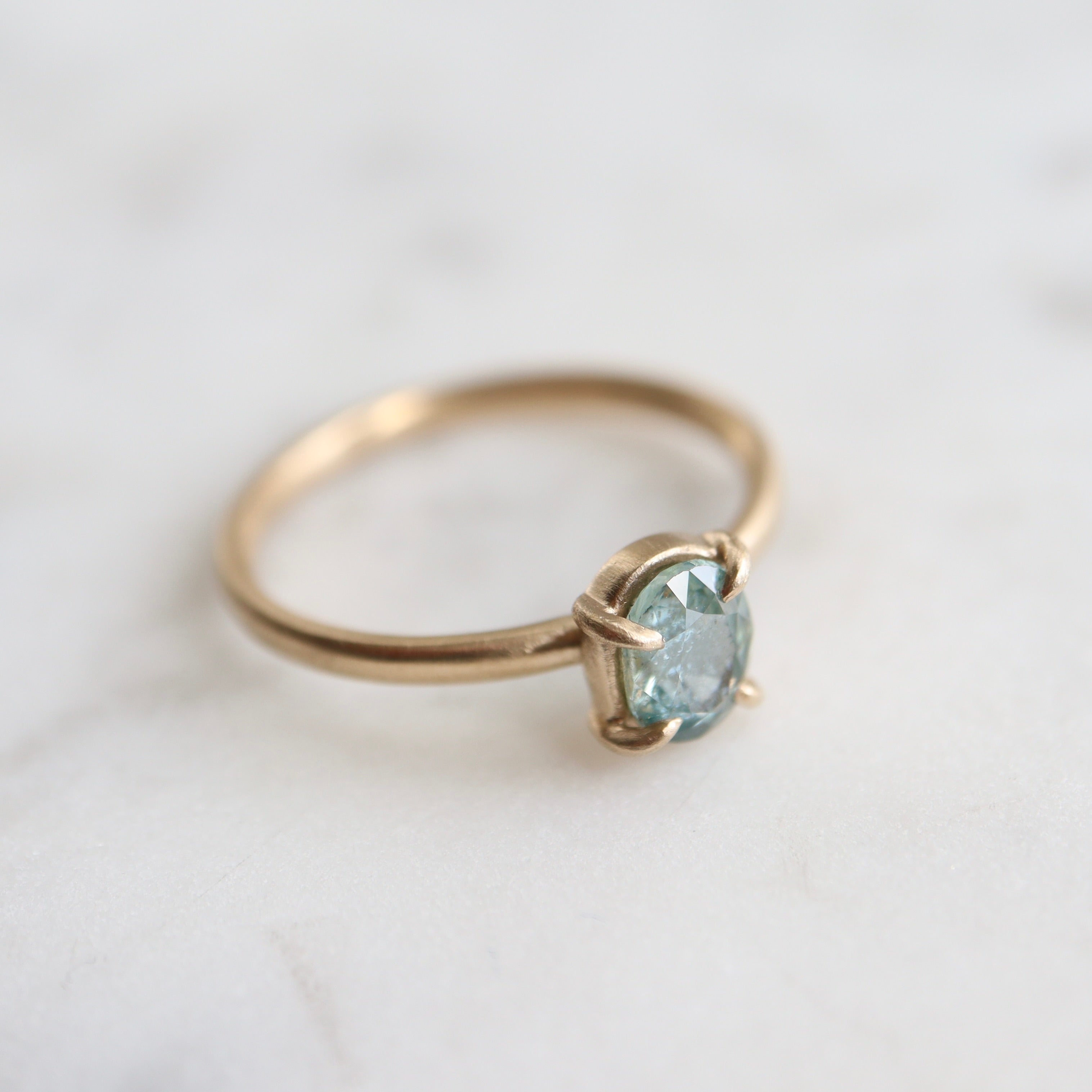 0.83ct Montana sapphire Vanity ring. The pale teal stone is set in 14k yellow gold with four prongs.