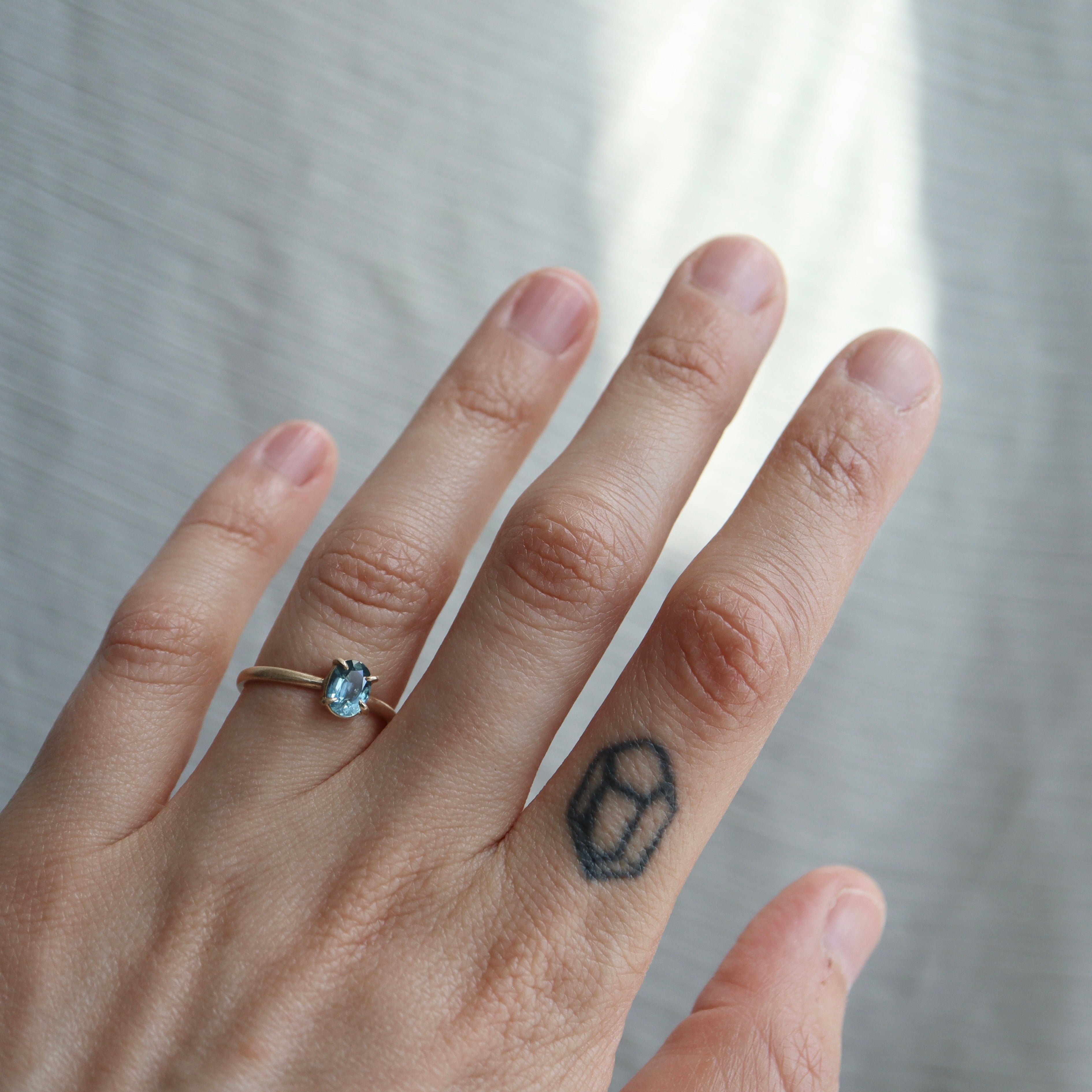 0.88ct Montana Sapphire Vanity Ring in 14k solid gold with four prongs on a hand. 