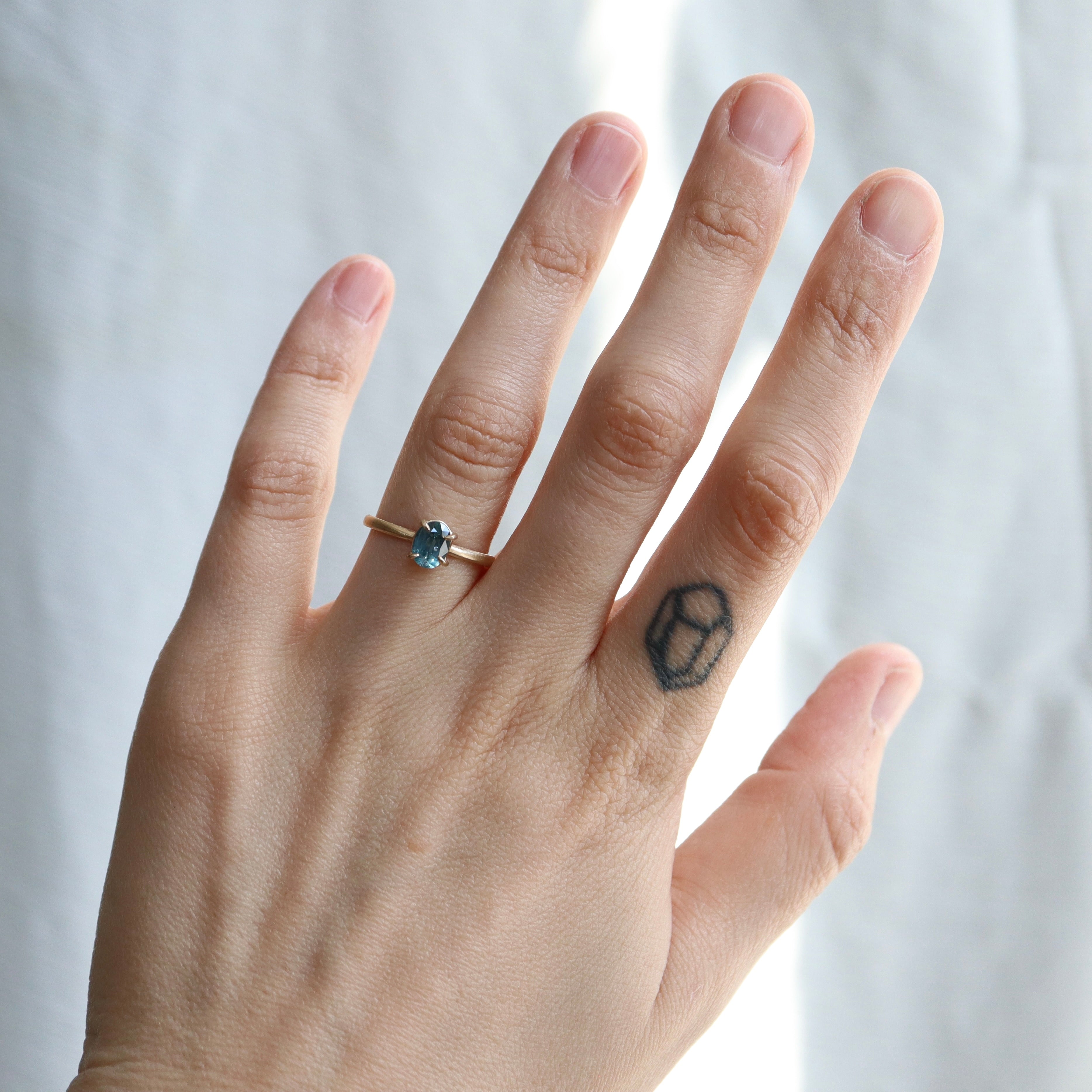 0.88ct Montana Sapphire Vanity Ring in 14k solid gold with four prongs on a hand. 