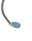 closeup of green and blue flash oval opal pendant set in gold branch prongs, on a black chain, on white. by hannah blount