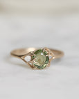 Gold ring with a green gemstone on a light background