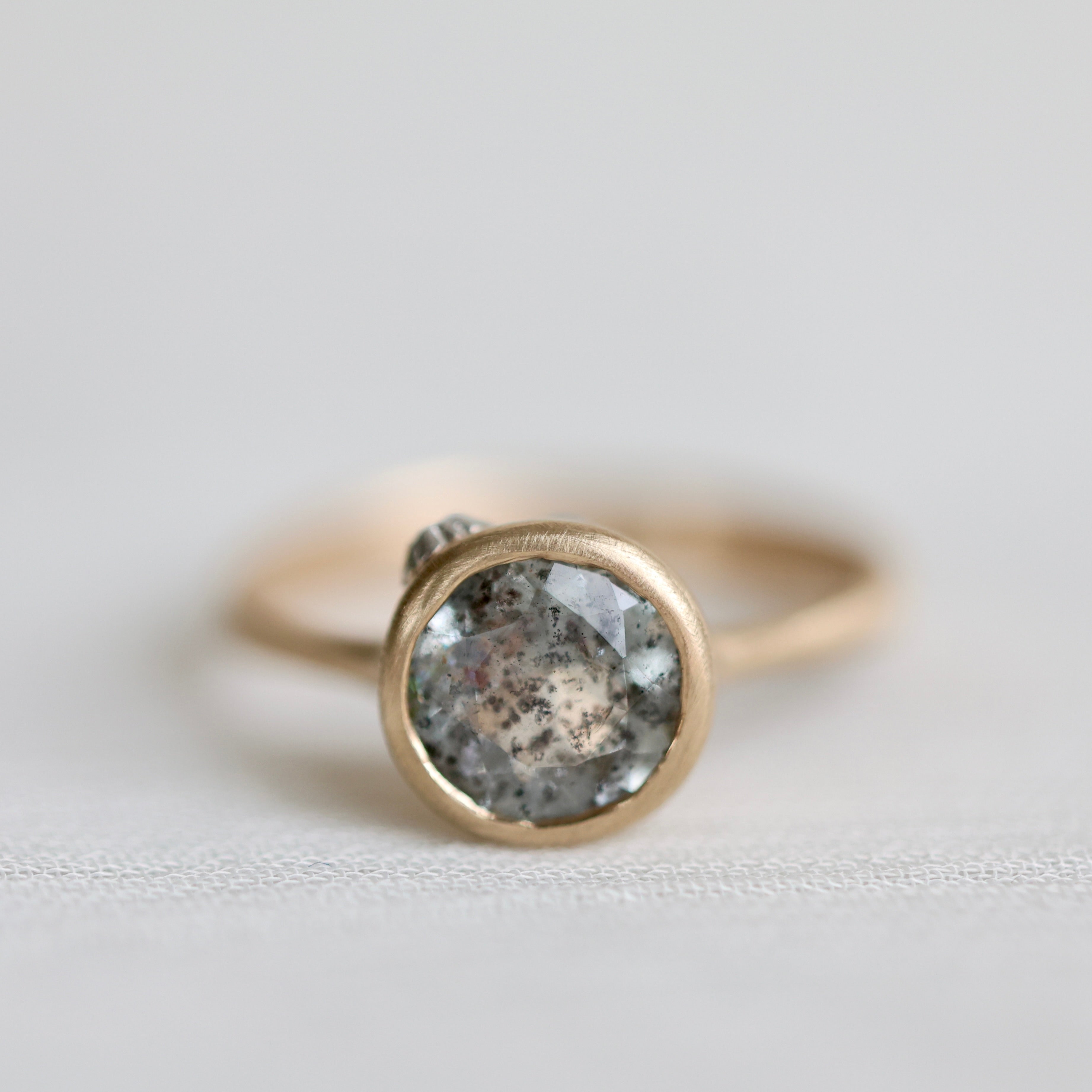 Gold ring with an aquamarine stone on a light gray background