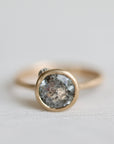 Gold ring with an aquamarine stone on a light gray background