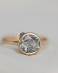 Gold ring with a gray stone on a light gray background