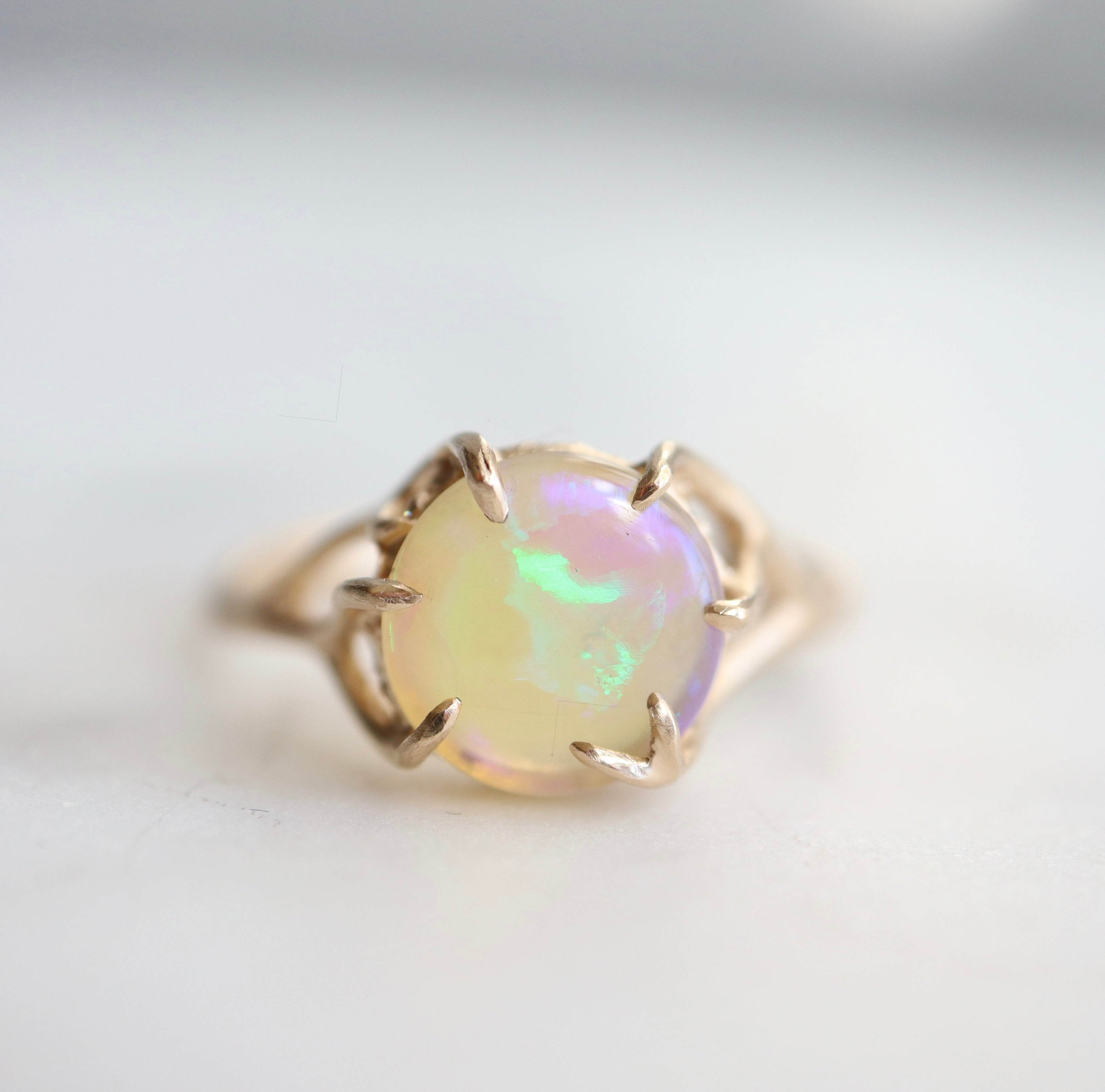 1.27ct Lightning Ridge Opal branch waiting ring set in 14k gold with a ring of modern melee diamonds. 