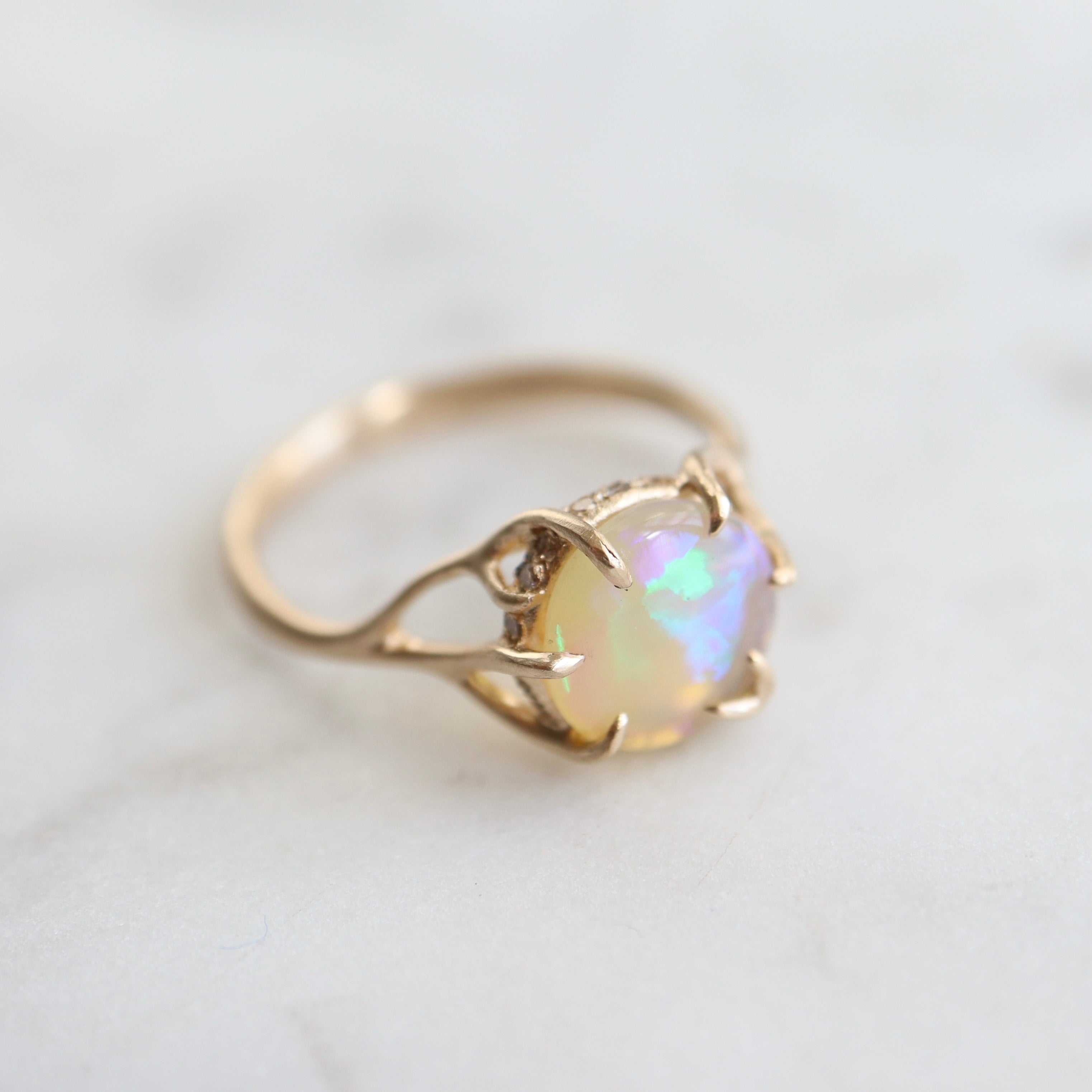 1.27ct Lightning Ridge Opal branch waiting ring set in 14k gold with a ring of modern melee diamonds. 