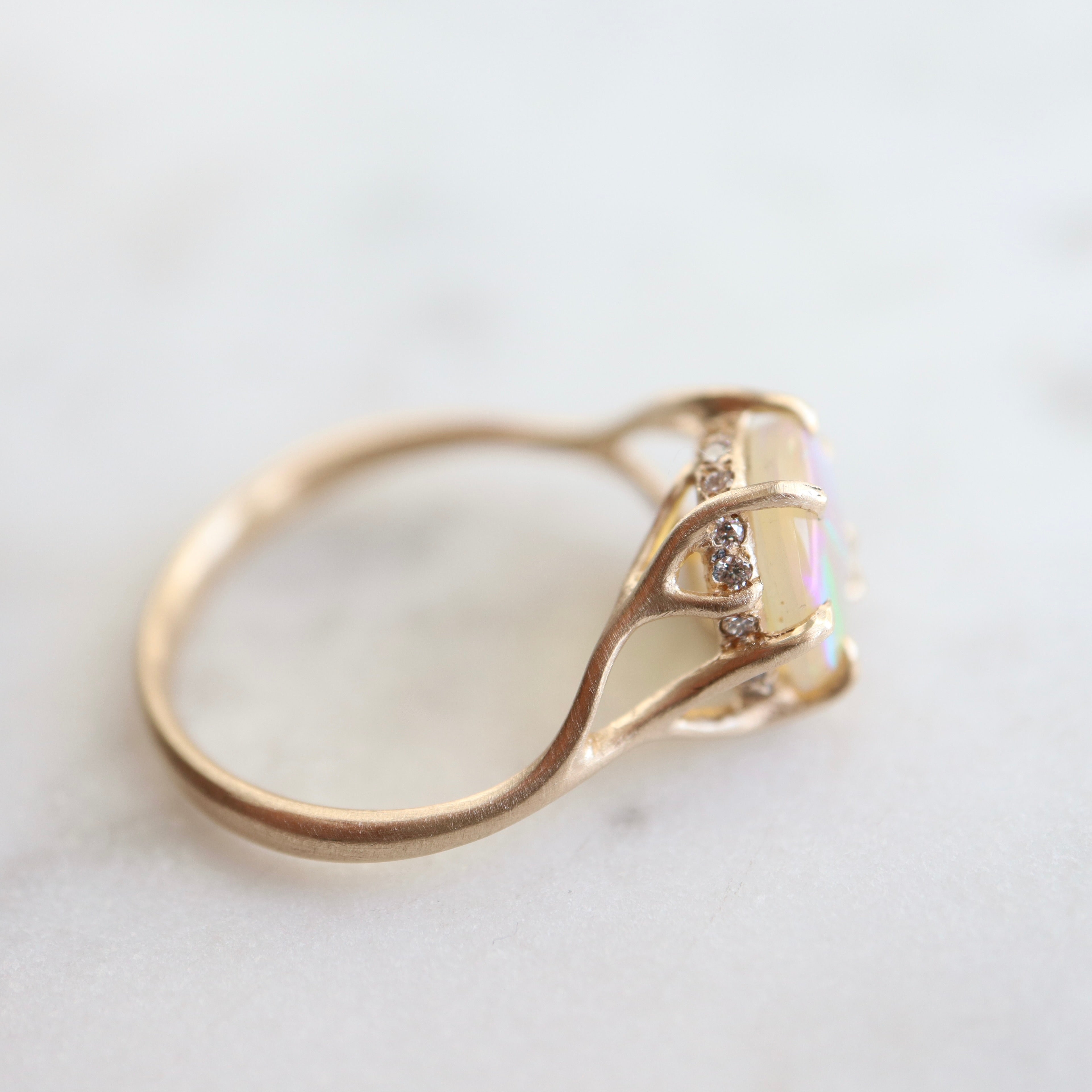 1.27ct Lightning Ridge Opal branch waiting ring set in 14k gold with a ring of modern melee diamonds. 