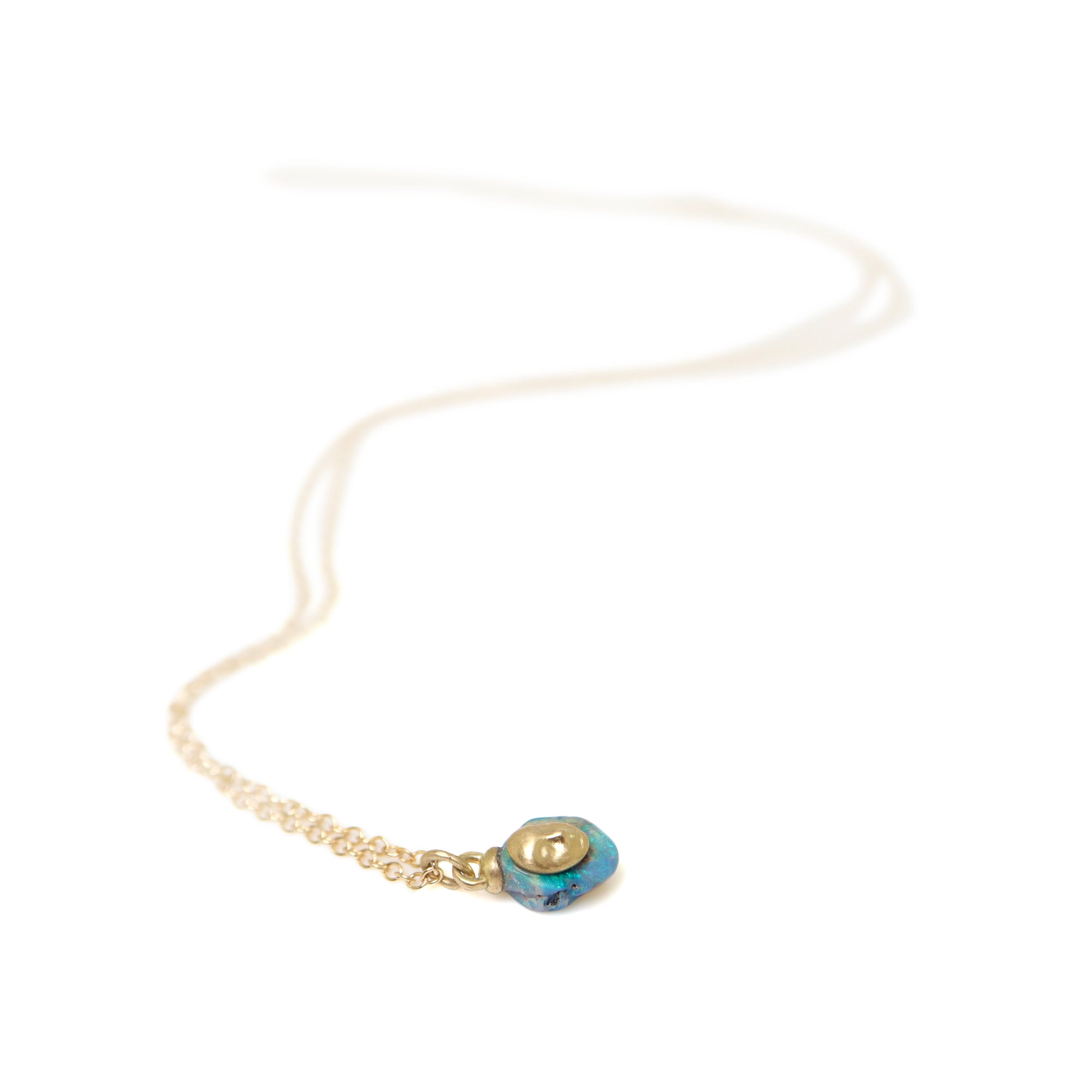 gold necklace with raw opal pendant featuring a gold face against white, by hannah blount