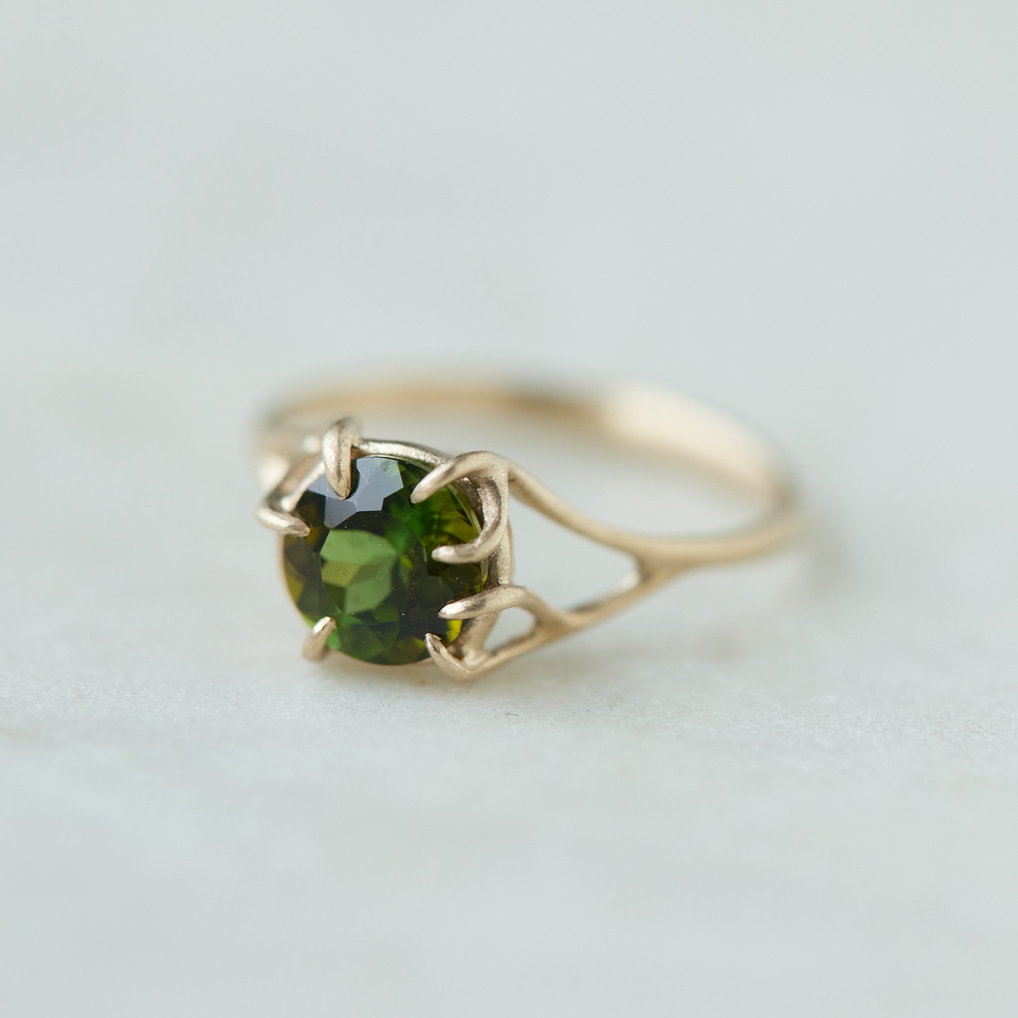 a lush green round tourmaline sits in gold branch prongs in this branch ring. 1/4 view.