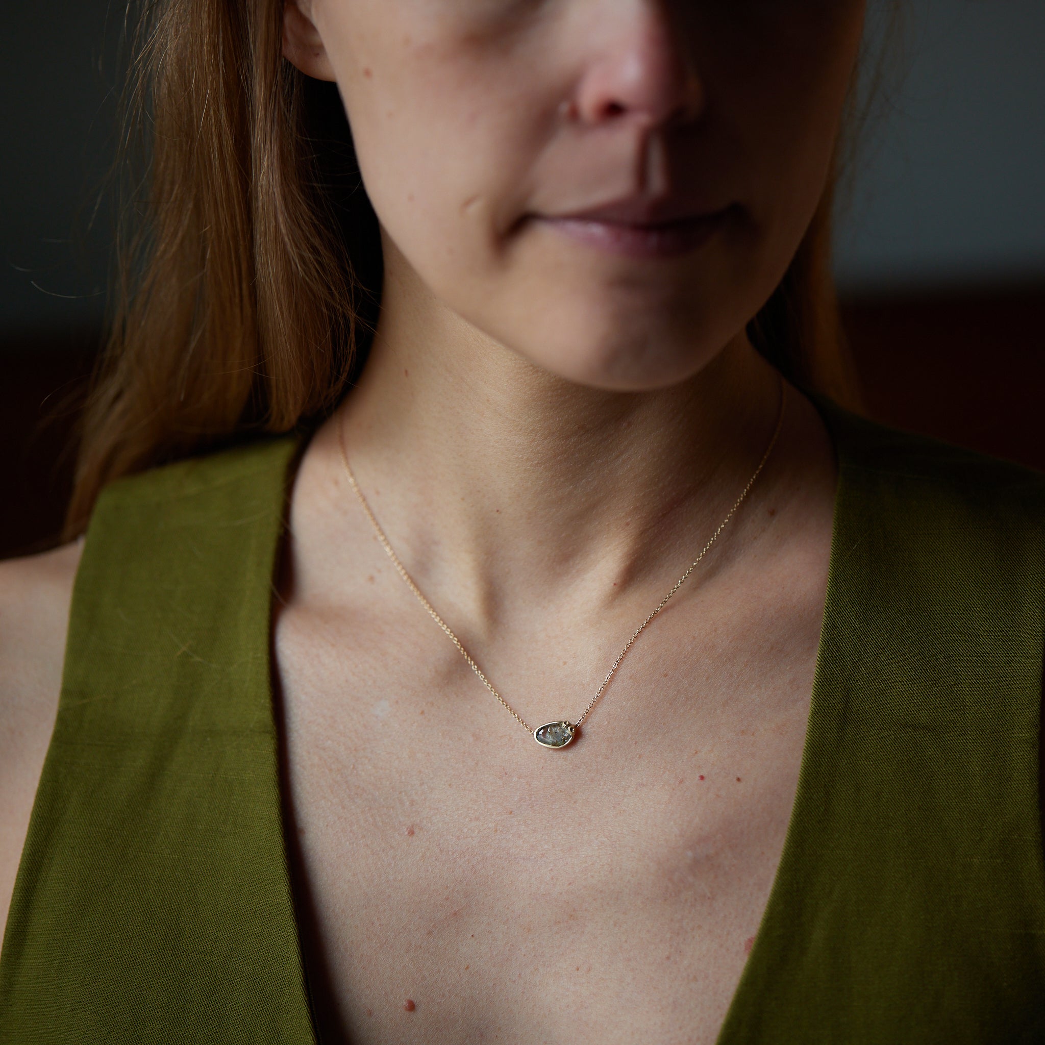 Sapphire necklace with gold barnacle setting on person