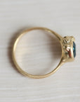 Gold ring with a blue gemstone on a white background