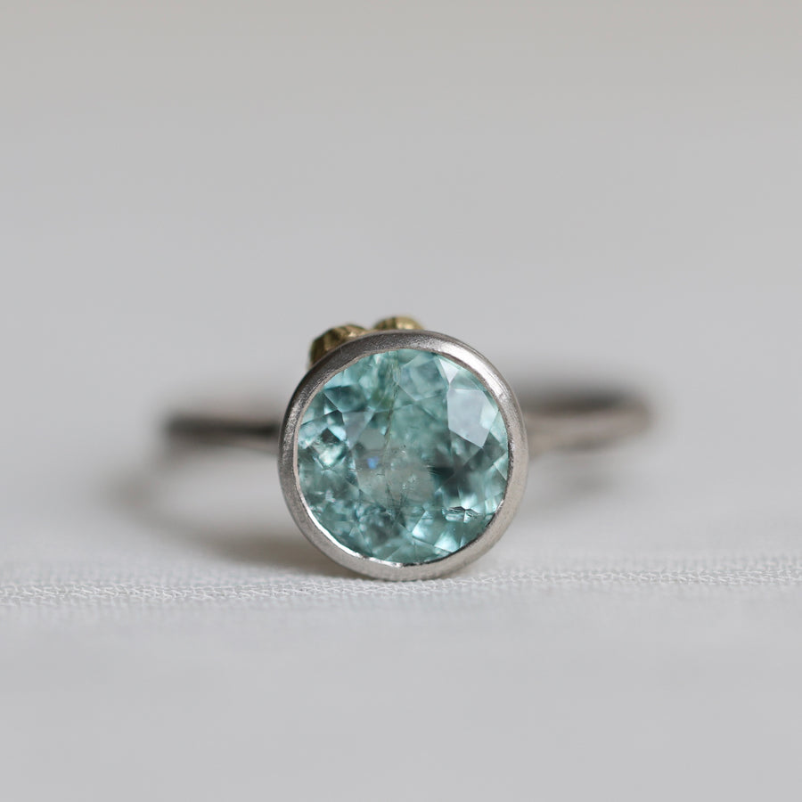 Ring with a blue gemstone on a light gray background