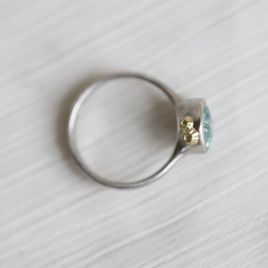 Silver ring with a blue gemstone on a white background