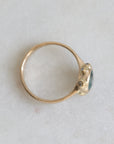 Gold ring with a blue gemstone on a light gray background