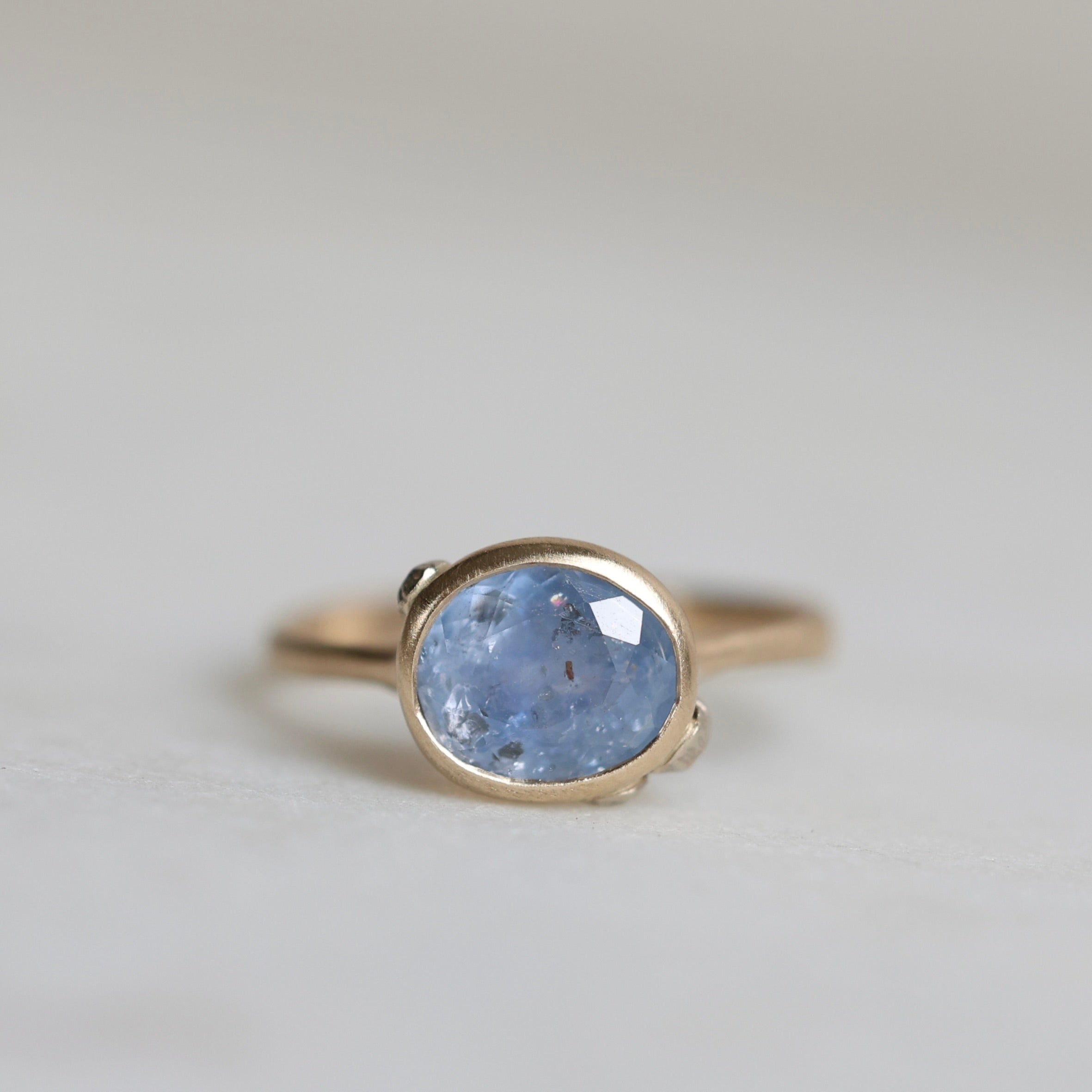 Ring with a blue gemstone on a light gray background