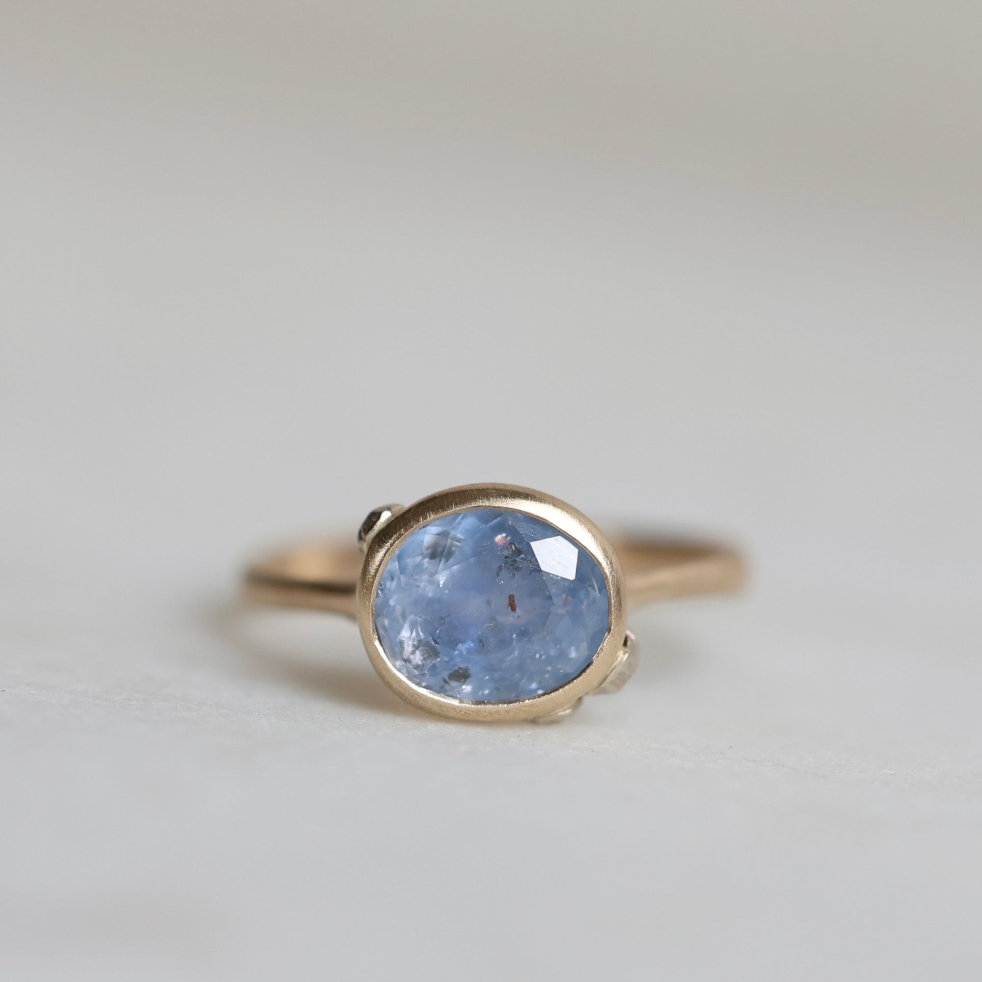 Ring with a blue gemstone on a light gray background