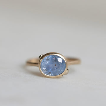 Ring with a blue gemstone on a light gray background