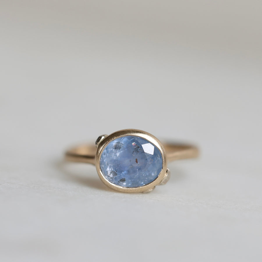Ring with a blue gemstone on a light gray background