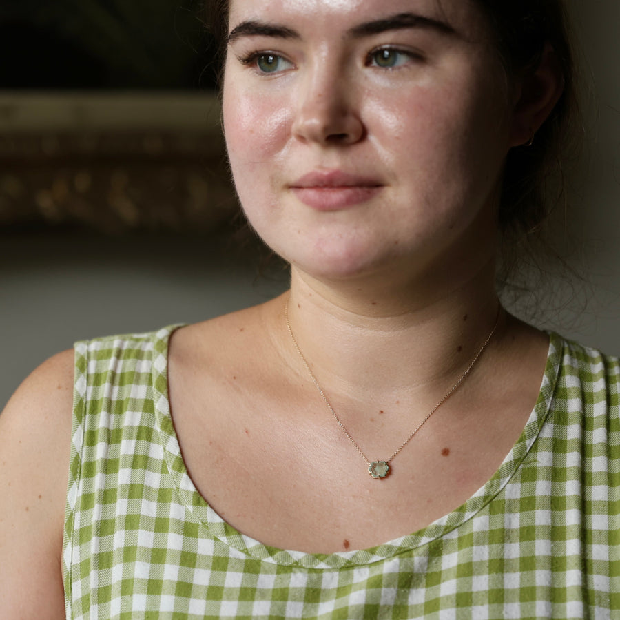 Woman wearing a green and white checkered dress with a necklace.