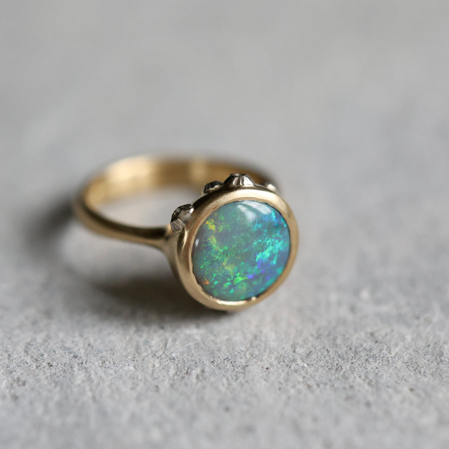 Gold ring with an opal stone on a gray surface
