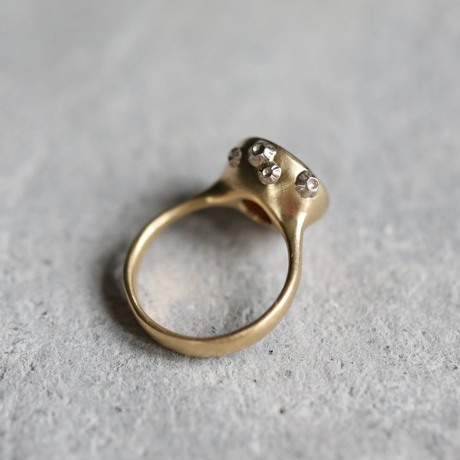 Gold ring with white gold barnacles on a gray surface