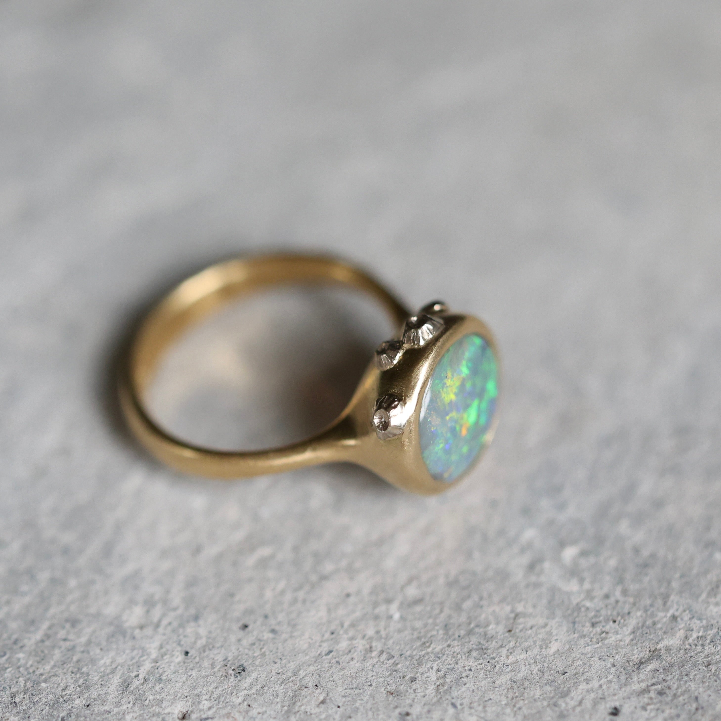 Gold ring with an opal stone on a gray background
