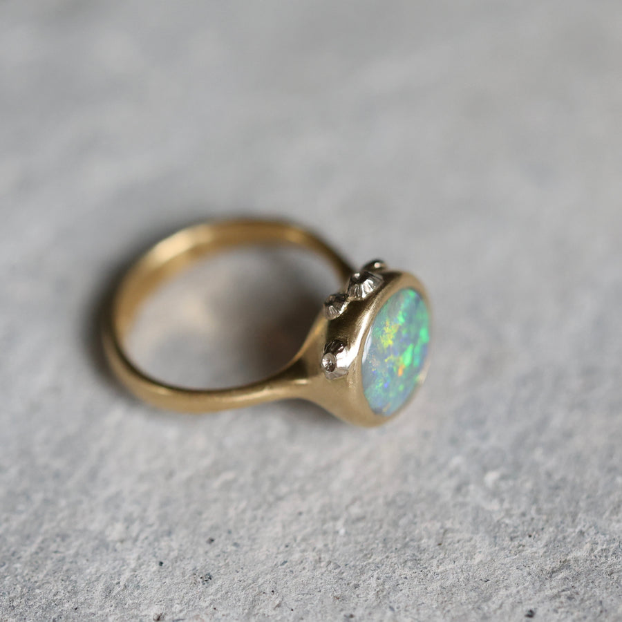 Gold ring with an opal stone on a gray background