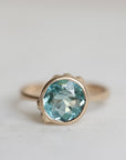 Ring with a blue gemstone on a light gray background