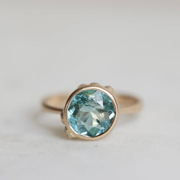 Ring with a blue gemstone on a light gray background