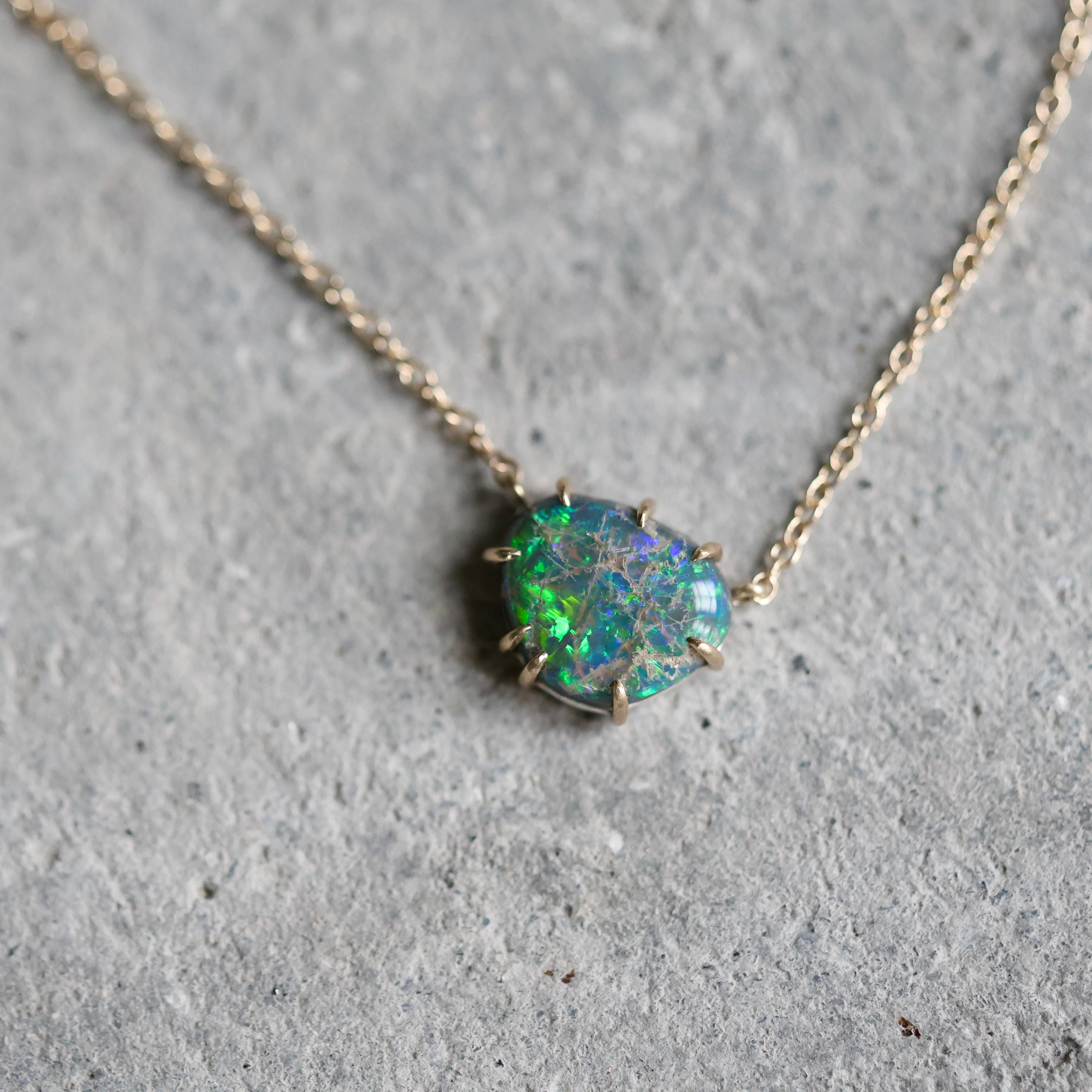 Opal necklace on a gray concrete surface