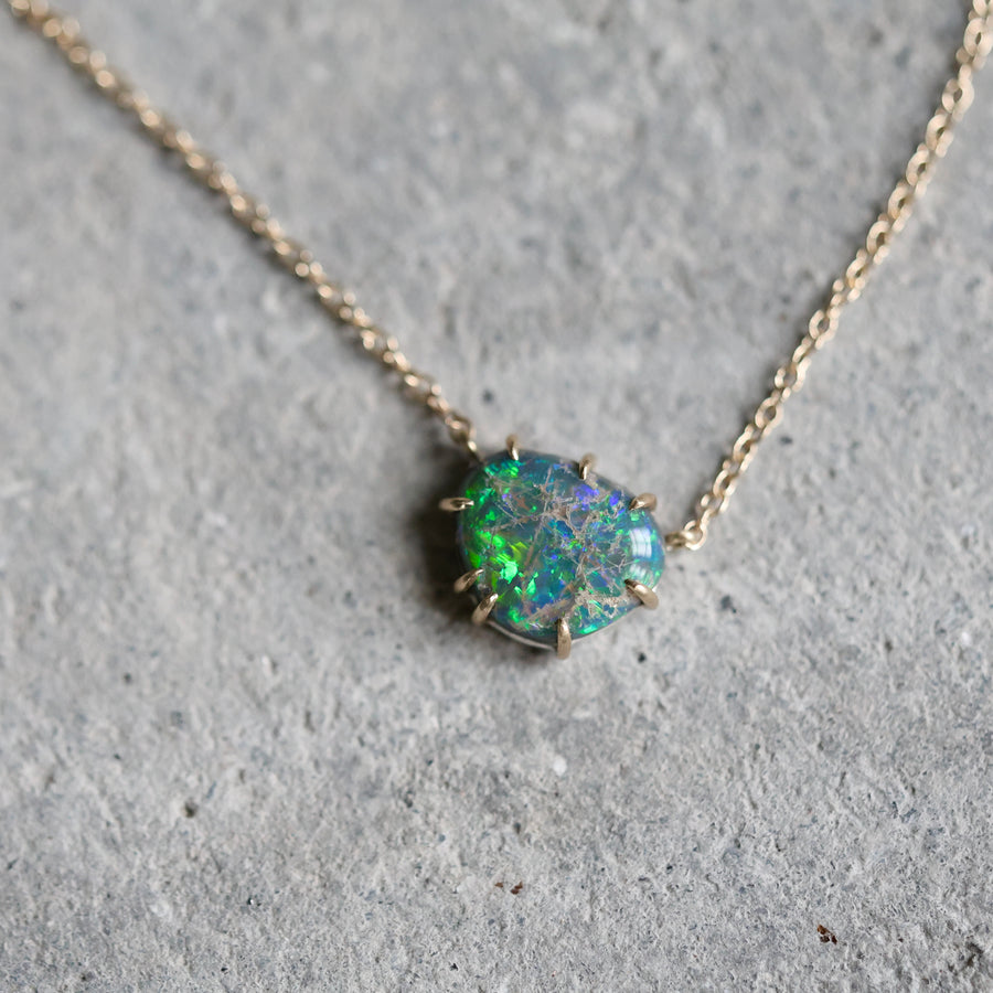 Opal necklace on a gray concrete surface