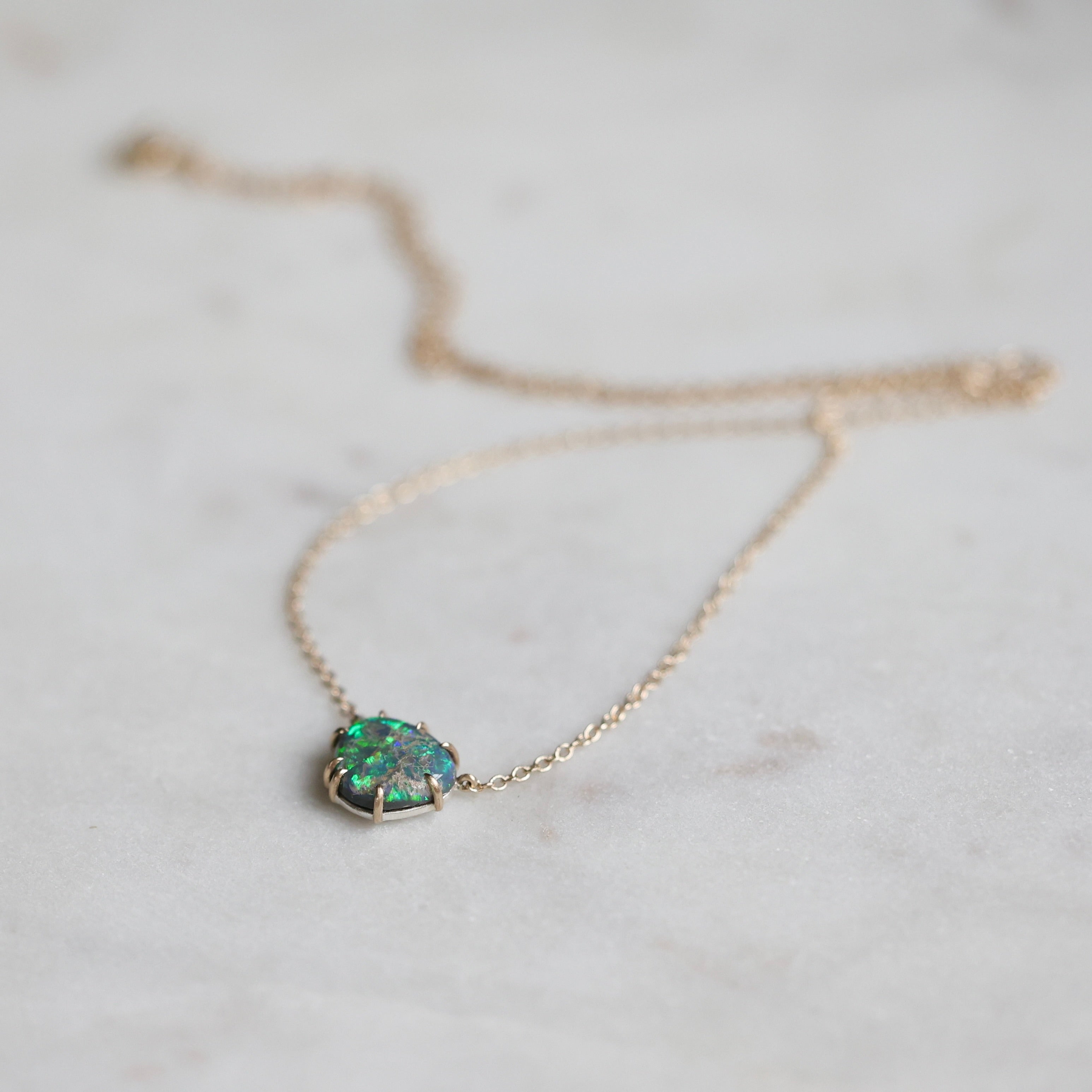 Necklace with a green opal pendant on a light background