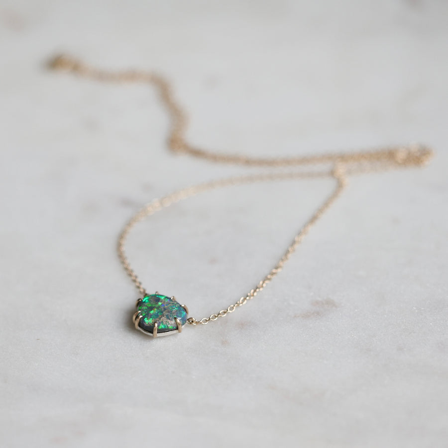 Necklace with a green opal pendant on a light background