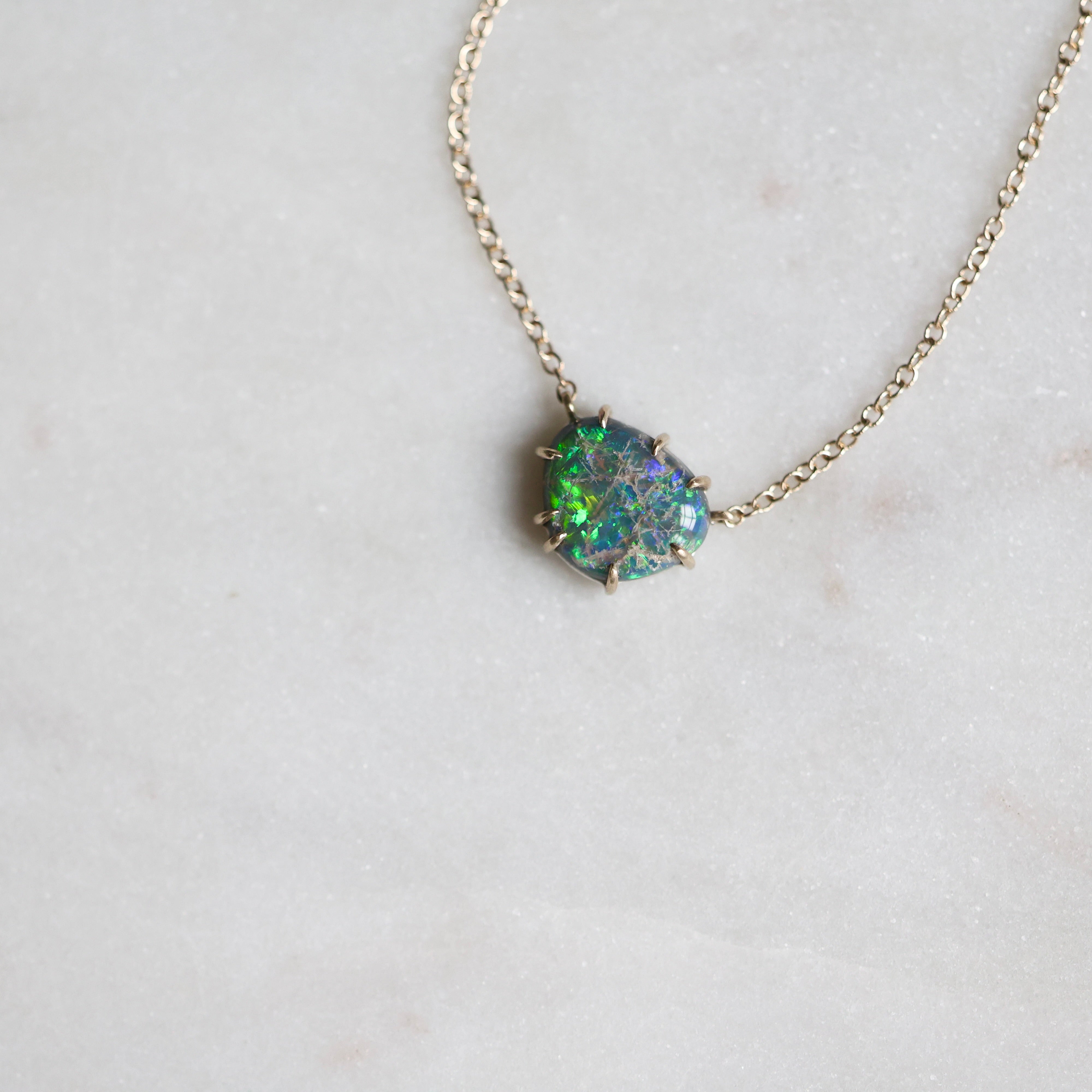 Necklace with a green opal pendant on a light gray background