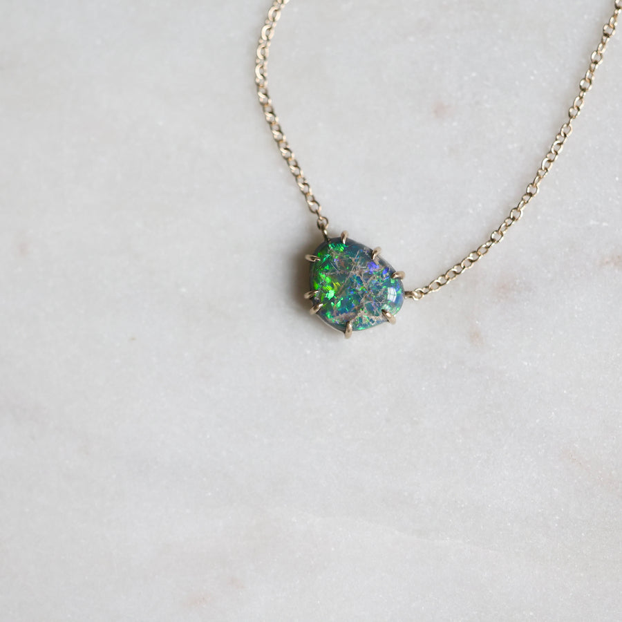 Necklace with a green opal pendant on a light gray background