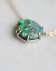 Necklace with a green opal pendant on a light gray background