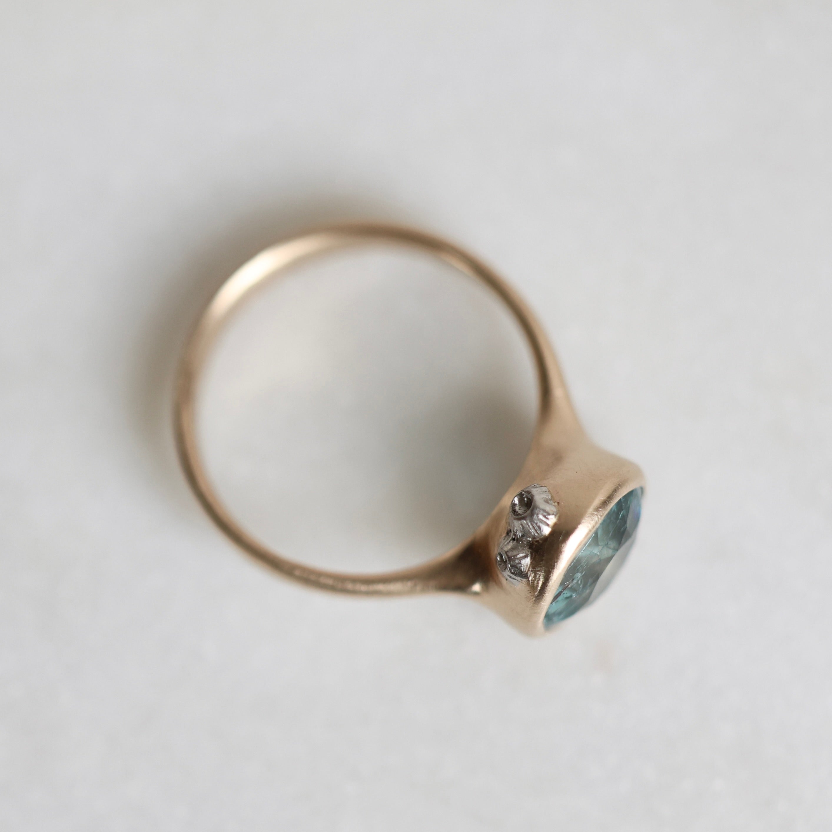 gold ring with blue gemstone, side profile