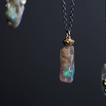 Opal pendant necklace on a dark background