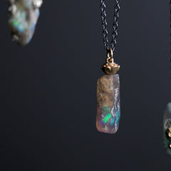 Opal pendant necklace on a dark background