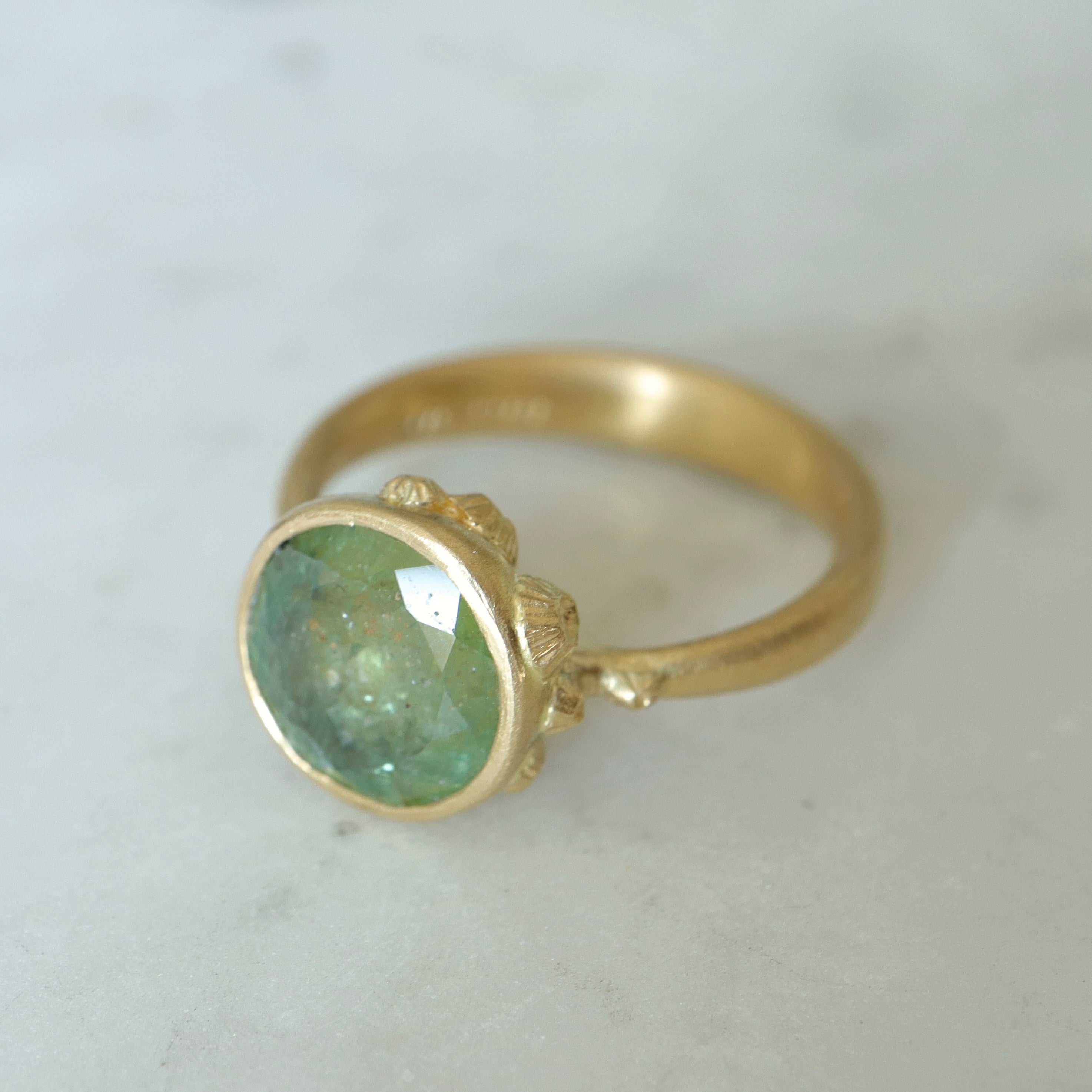 mossy green montana sapphire set in a gold ring with barnacles