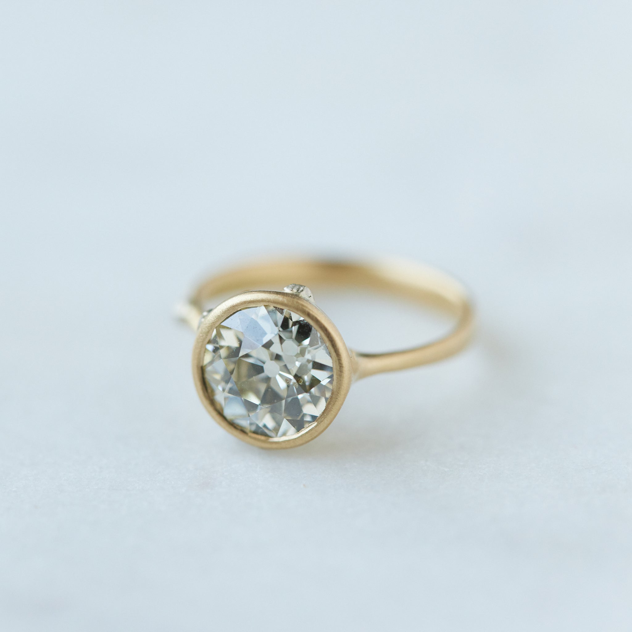 Diamond ring with gold bezel setting and white gold barnacles. THe barnacles have diamonds in them. 1/4 view.