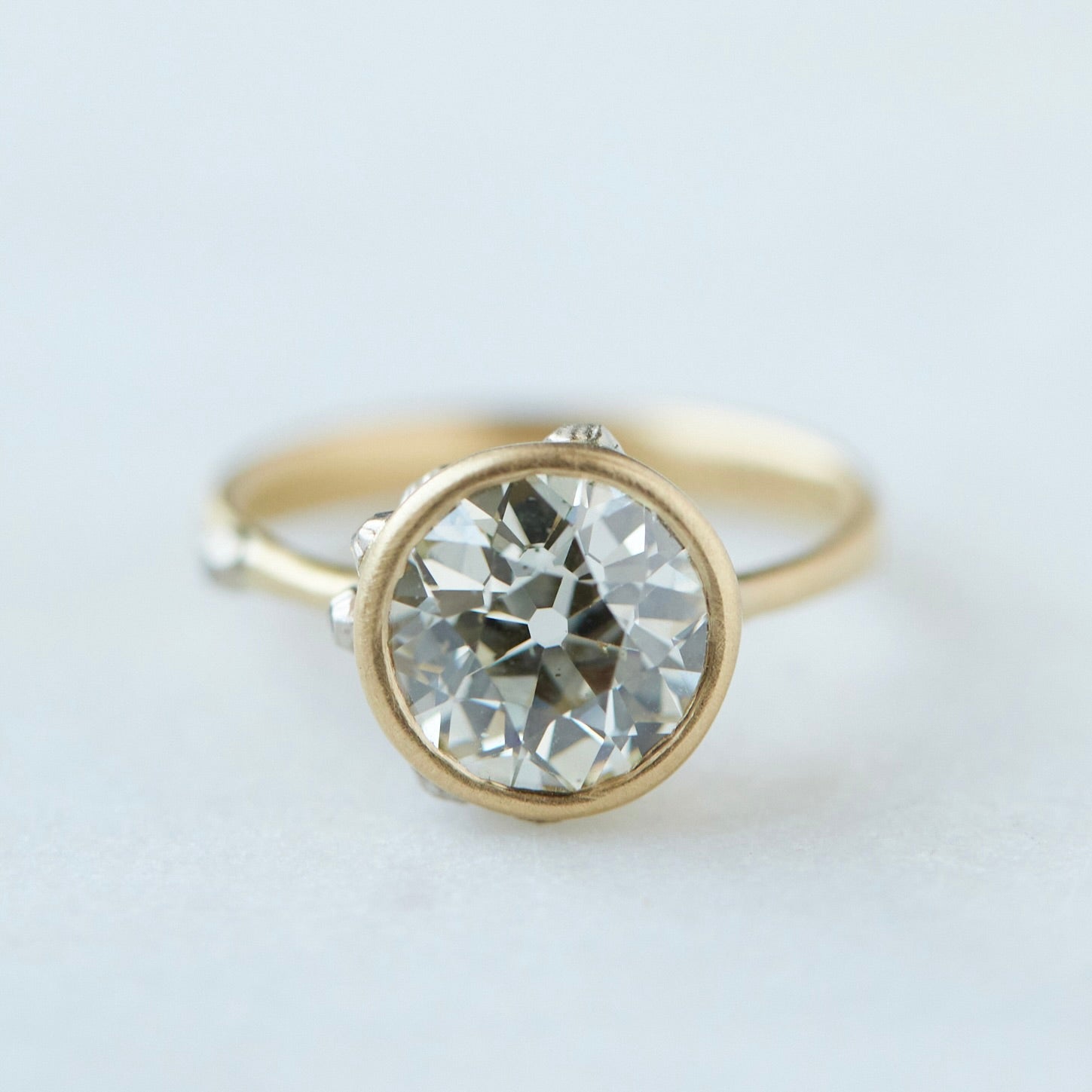 Diamond ring with gold bezel setting and white gold barnacles. THe barnacles have diamonds in them.