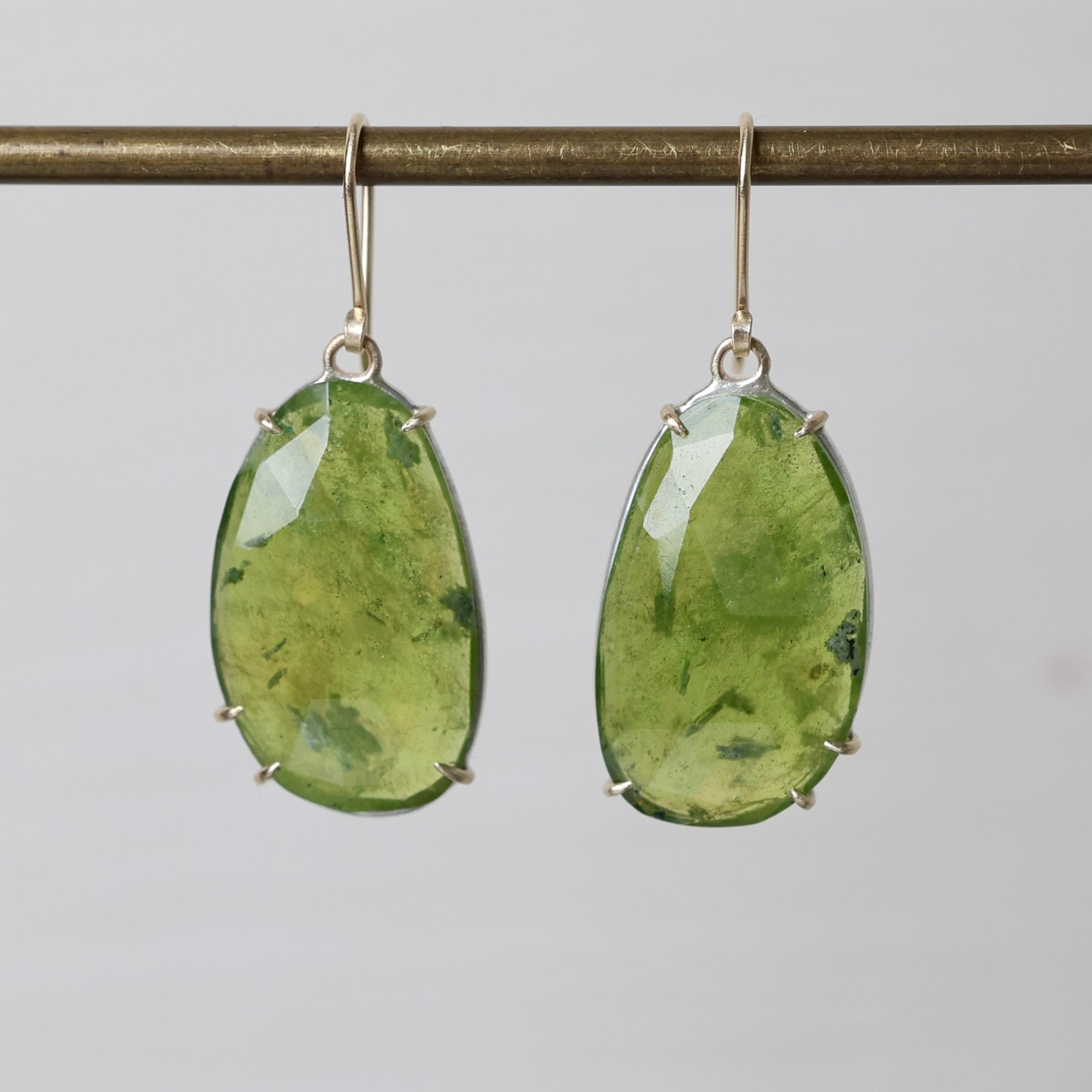 Green teardrop earrings on a gray background