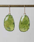 Green teardrop earrings on a gray background