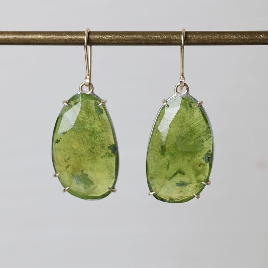 Green teardrop earrings on a gray background
